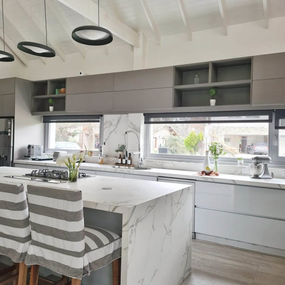 Cocina de El Ombu con mesada e isla en Dekton aura.