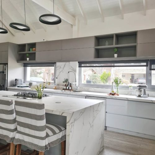 Cocina de El Ombu con mesada e isla en Dekton aura.