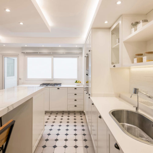 Cocina de Araoz con mesada en Silestone miami white e isla en Dekton calacatta natura.