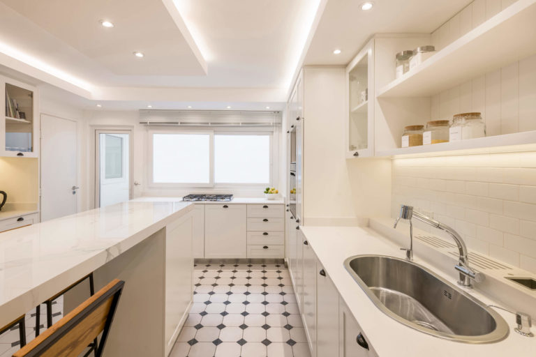 Cocina de Araoz con mesada en Silestone miami white e isla en Dekton calacatta natura.