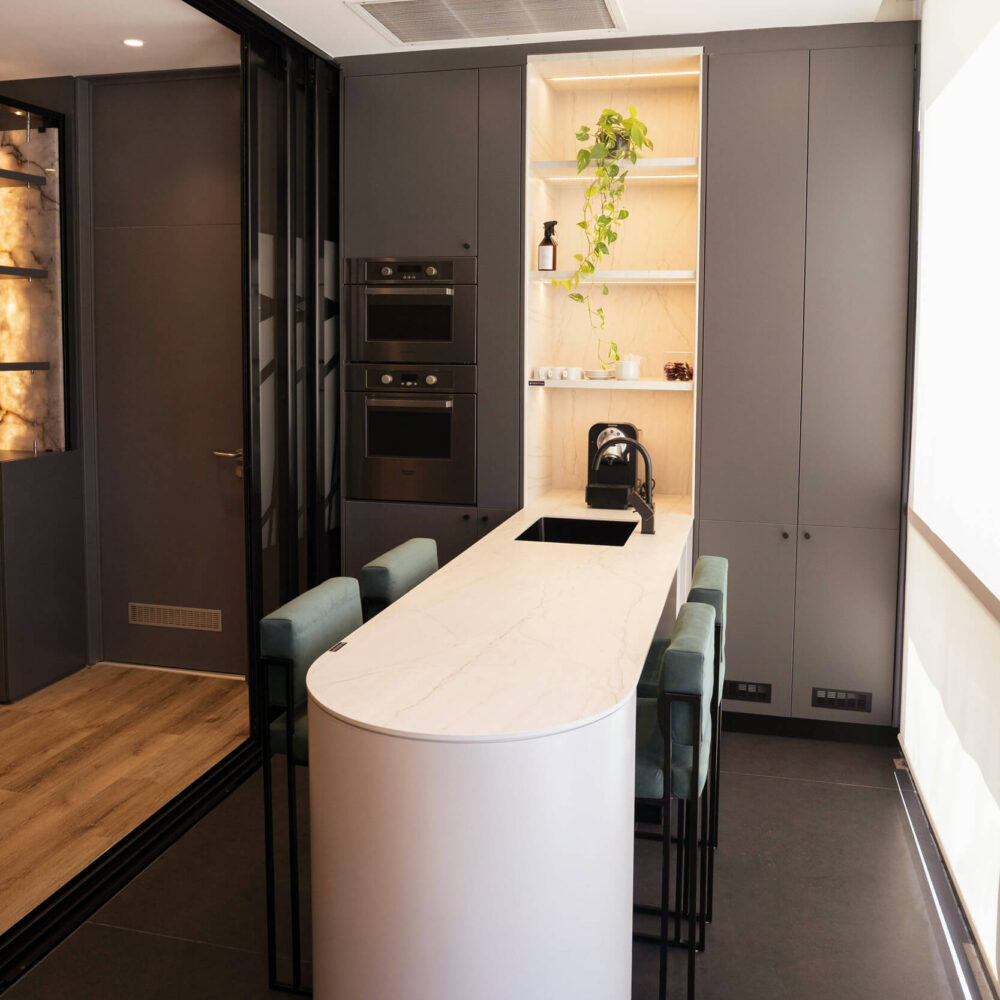 Cocina del estudio con mesada y nicho en Dekton Neural y piso en Dekton Modulado Eter.
